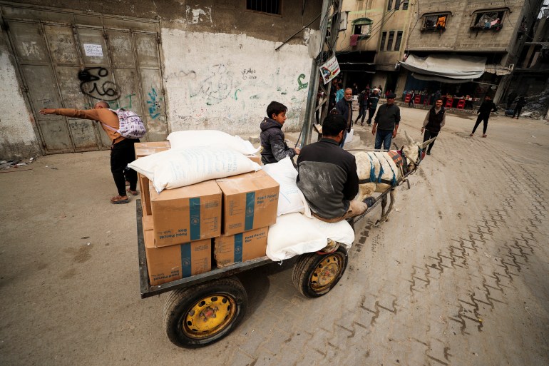 Palestinians transport aid supplies on an animal-drawn cart, amid a ceasefire between Hamas and Israel, in Gaza City, February 3, 2025. REUTERS/Dawoud Abu Alkas