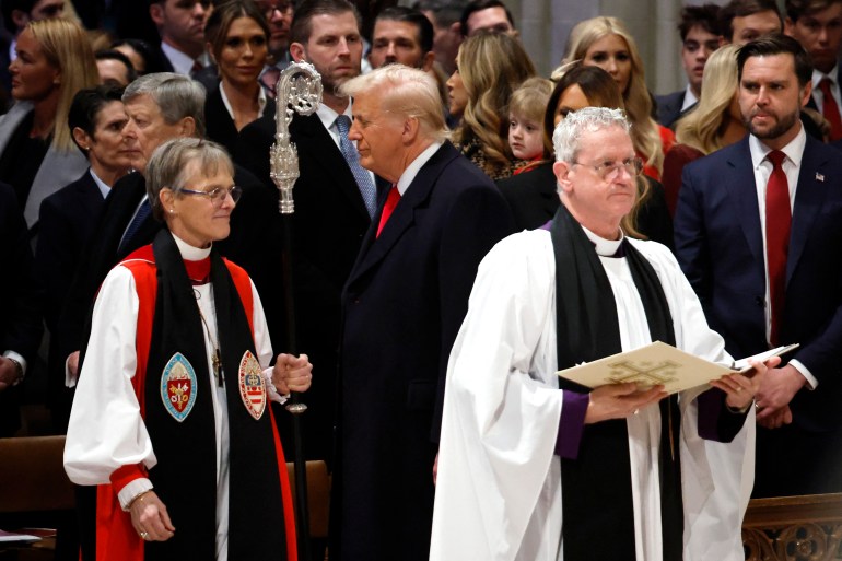 WASHINGTON, DC - JANUARY 21: Bishop Mariann Edgar Budde (L) arrives with Ven. Steve Seely (2nd-R) as U.S. President Donald Trump (C) and U.S. Vice President J.D. Vance (R) look on during the National Prayer Service at Washington National Cathedral on January 21, 2025 in Washington, DC. Tuesday marks Trump's first full day of his second term in the White House. Chip Somodevilla/Getty Images/AFP (Photo by CHIP SOMODEVILLA / GETTY IMAGES NORTH AMERICA / Getty Images via AFP)