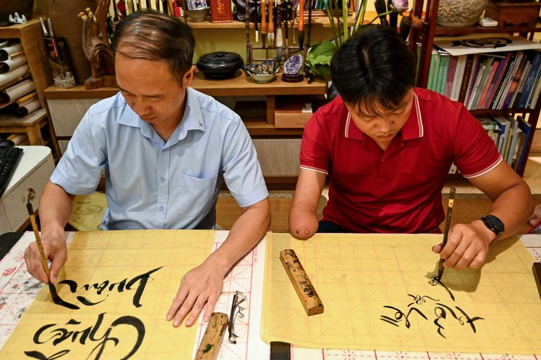 This photo taken on May 15, 2025 shows students learning calligraphy at the home of calligrapher Nguyen Thanh Tung in Hanoi. At a calligraphy class in Hanoi, Hoang Thi Thanh Huyen slides her brush across the page to form the letters and tonal marks of Vietnam's unique modern script, in part a legacy of French colonial rule. (Photo by Nhac NGUYEN / AFP) / TO GO WITH VIETNAM-FRANCE-ALPHABET-DIPLOMACY-MACRON, FOCUS